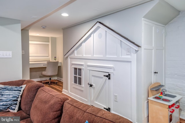 interior space with wood finished floors, built in study area, and recessed lighting