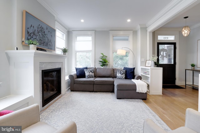 living room featuring a fireplace, recessed lighting, ornamental molding, wood finished floors, and baseboards