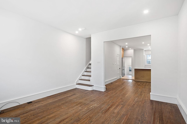 spare room with stairway, recessed lighting, wood finished floors, and baseboards