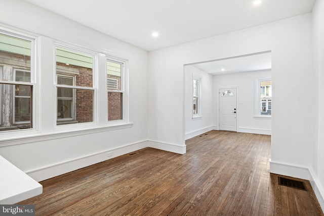 spare room with recessed lighting, dark wood-style flooring, visible vents, and baseboards