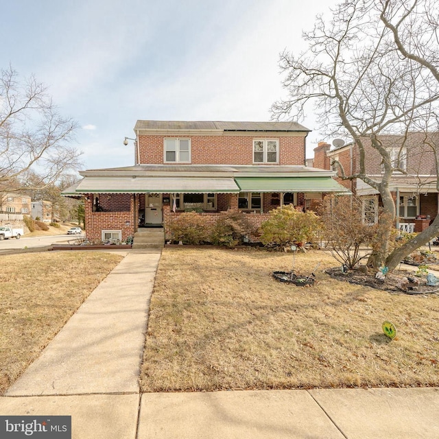 view of front of home featuring brick siding and a front lawn