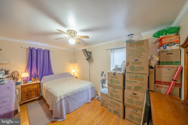 bedroom featuring crown molding, light wood-style flooring, and a ceiling fan