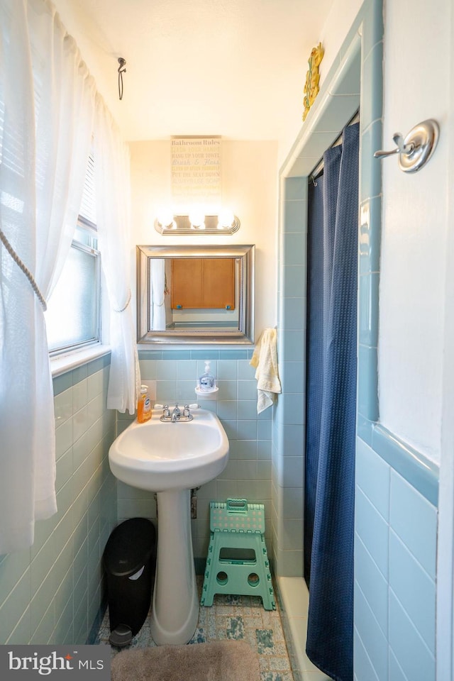 full bath with curtained shower, tile walls, and a wainscoted wall