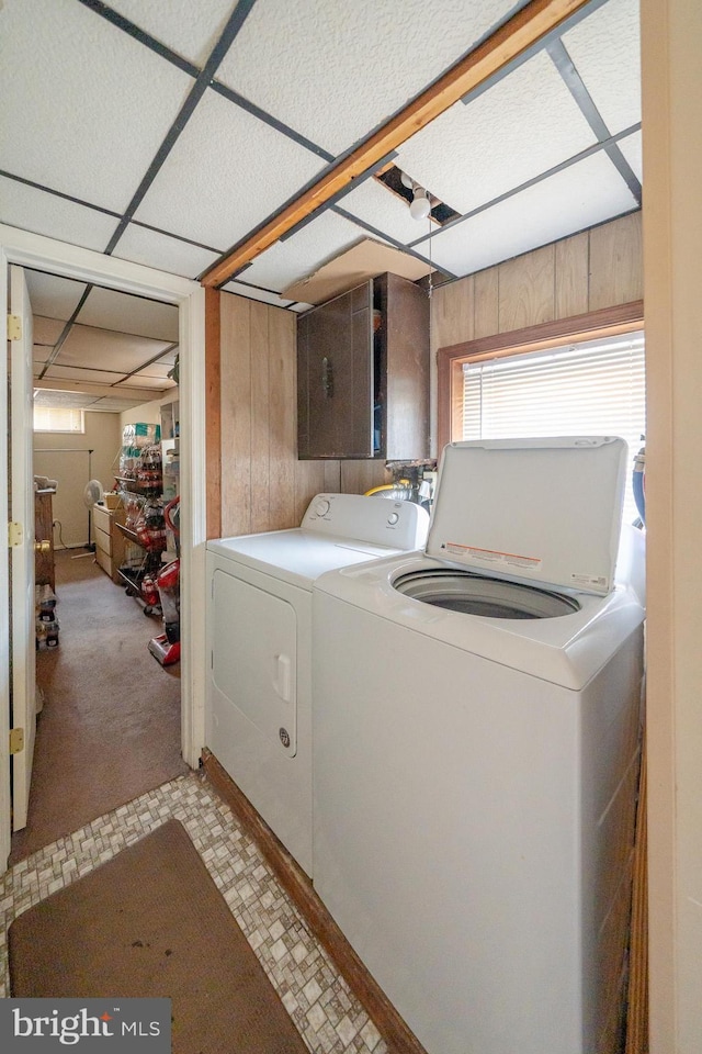 washroom with laundry area, wooden walls, separate washer and dryer, and light floors