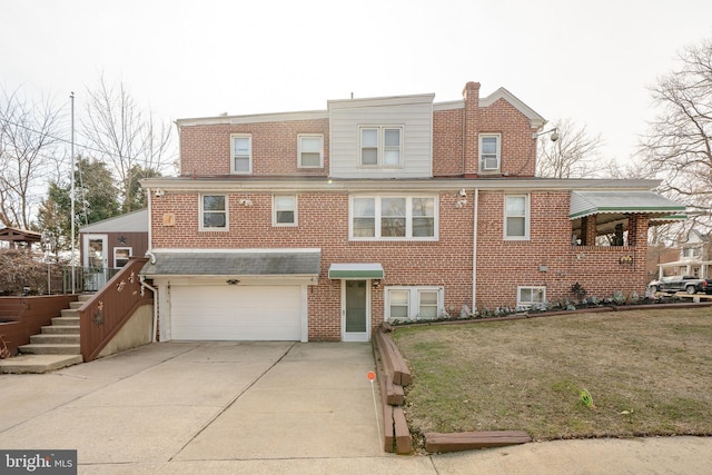 townhome / multi-family property with concrete driveway, an attached garage, brick siding, and a front yard