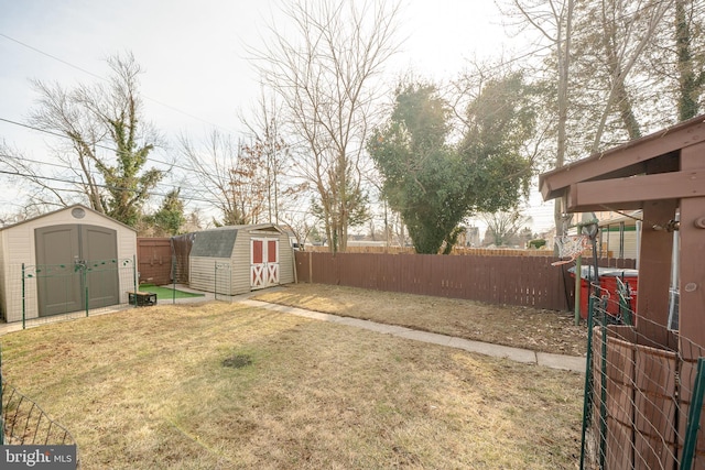 view of yard featuring an outbuilding, a storage shed, and a fenced backyard