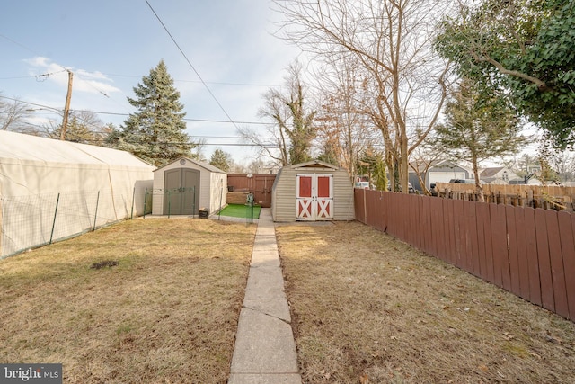 view of yard featuring a shed, an outdoor structure, and a fenced backyard