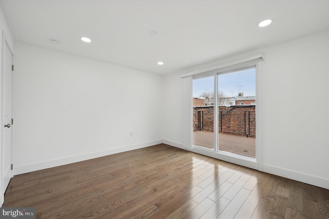 unfurnished room featuring baseboards, dark wood-type flooring, and recessed lighting