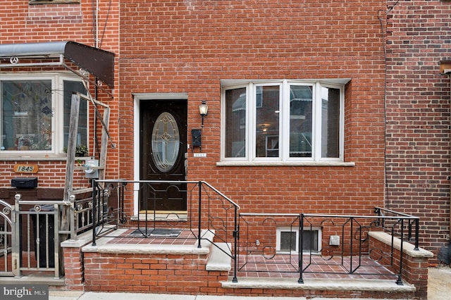 doorway to property with brick siding