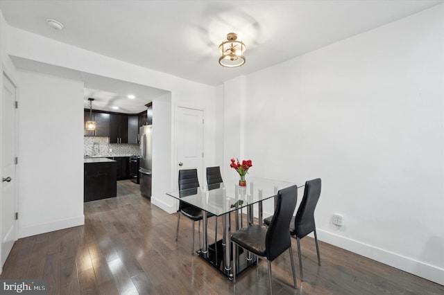 dining space with dark wood-type flooring and baseboards