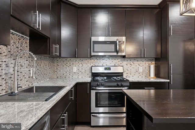 kitchen with stainless steel appliances, a sink, and dark brown cabinetry