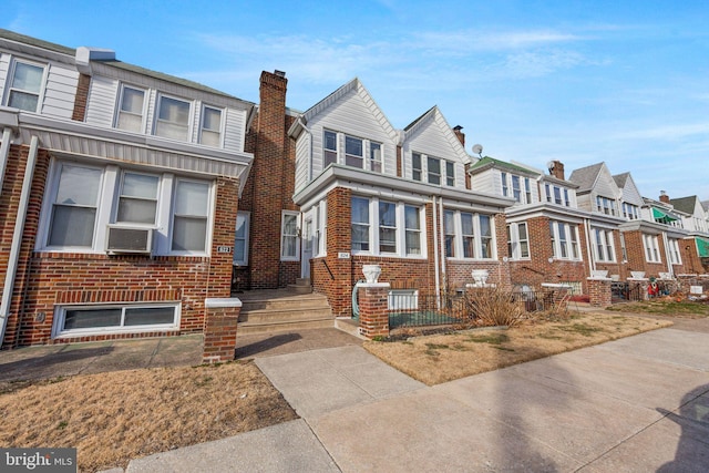 view of property with brick siding, cooling unit, and a residential view