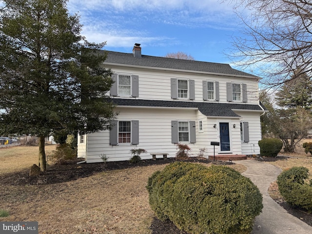 view of front of house with roof with shingles and a chimney