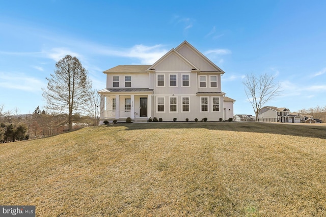 view of front of house with a standing seam roof, metal roof, and a front lawn