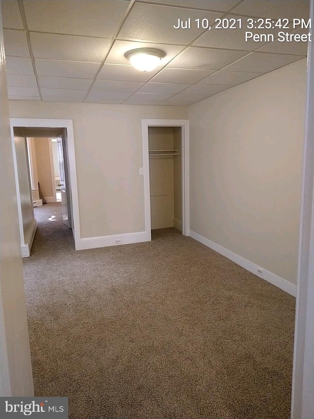 unfurnished room featuring a paneled ceiling, carpet, baseboards, and baseboard heating