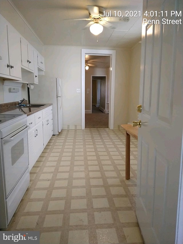 kitchen with white electric stove, light floors, dark countertops, white cabinets, and a sink