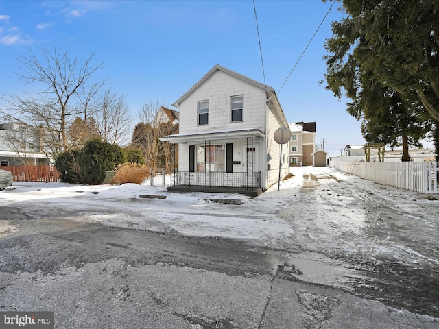 view of front of property with a porch and fence