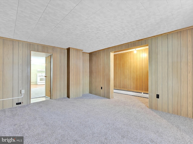 carpeted empty room with a baseboard radiator and wood walls