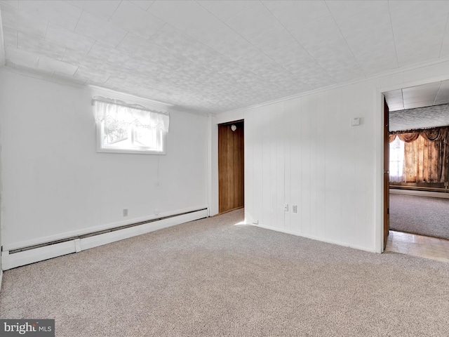 unfurnished room with plenty of natural light, carpet floors, baseboard heating, and a baseboard radiator