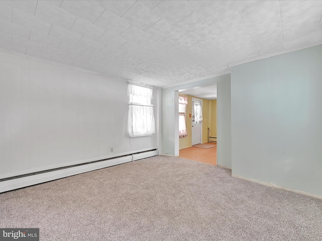 spare room with a baseboard heating unit, crown molding, and light colored carpet