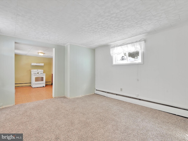 spare room featuring a baseboard heating unit and light colored carpet