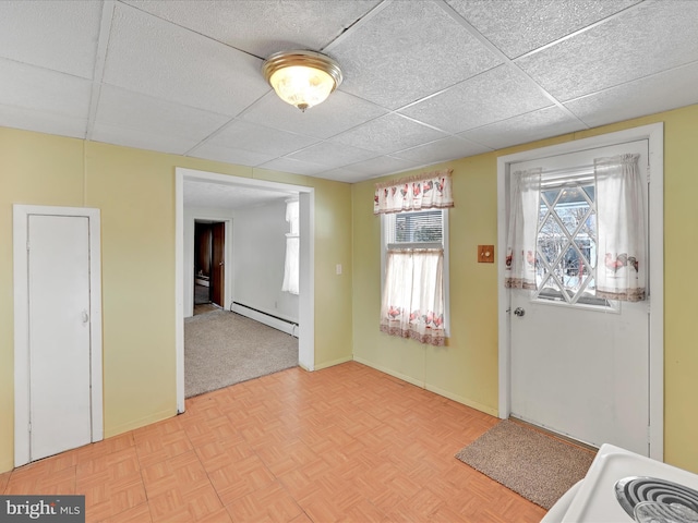 foyer entrance with plenty of natural light, a drop ceiling, and a baseboard radiator