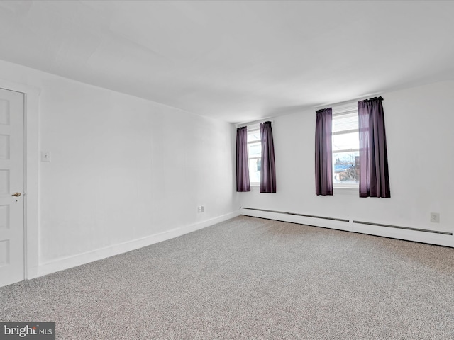 spare room with a baseboard radiator, baseboards, and carpet