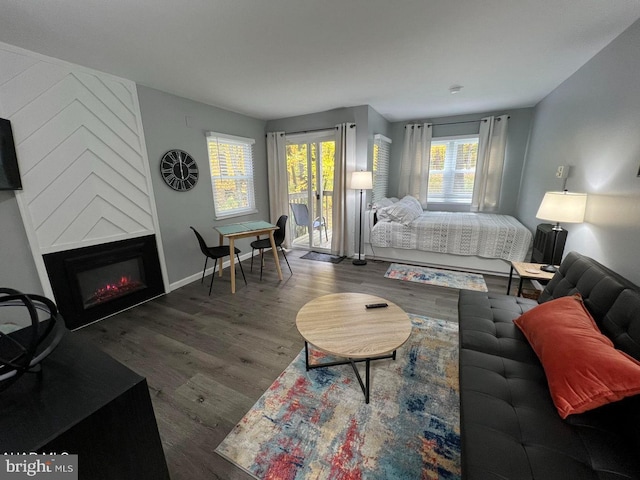 living area with dark wood-type flooring, a fireplace, and baseboards