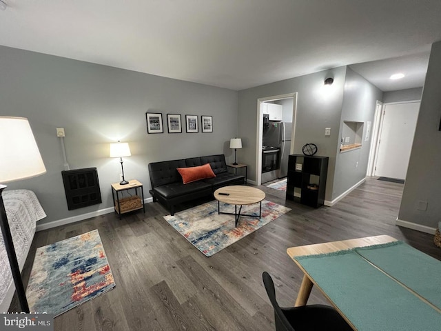 living area with dark wood-style flooring and baseboards