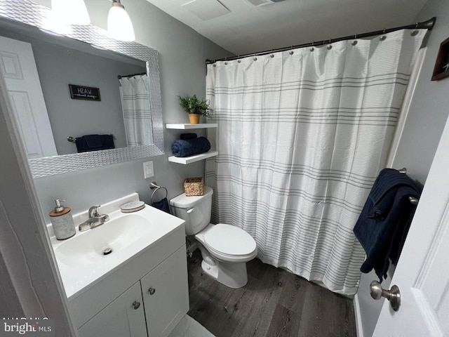 bathroom with toilet, visible vents, wood finished floors, and vanity