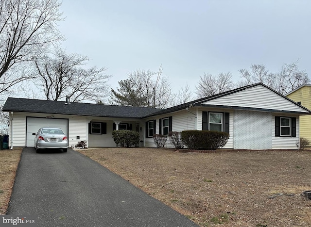 ranch-style home with driveway, an attached garage, and brick siding