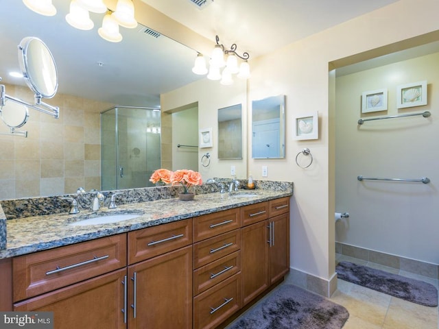 bathroom with a stall shower, tile patterned floors, a sink, and double vanity