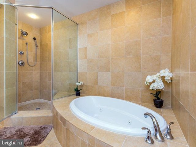 bathroom featuring a jetted tub and a shower stall