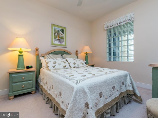 bedroom featuring light carpet, baseboards, and a ceiling fan