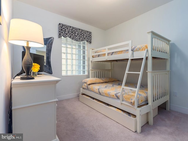 bedroom featuring light carpet and baseboards