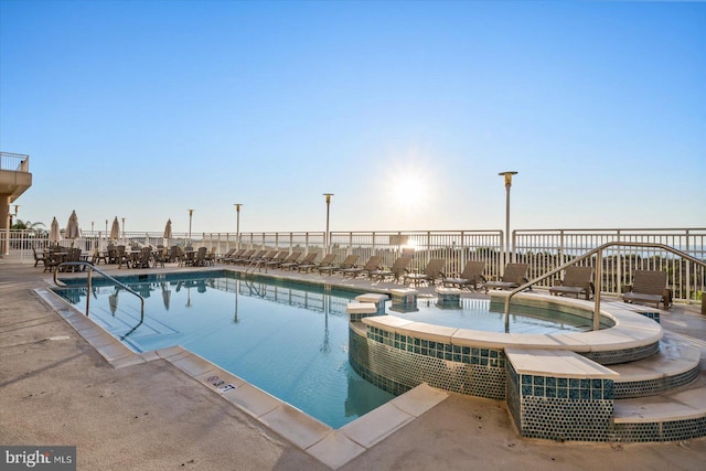 community pool featuring a community hot tub and fence