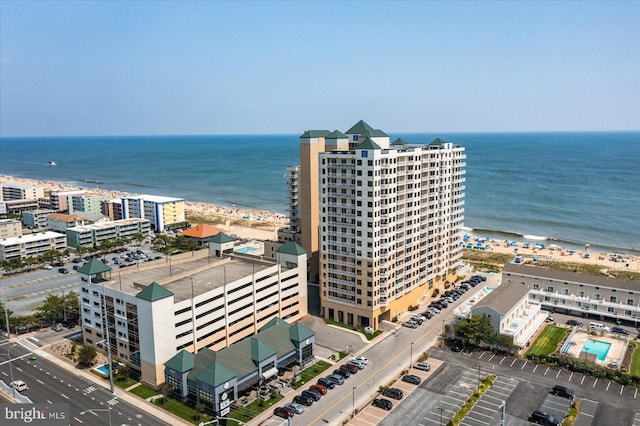 aerial view with a water view, a view of the beach, and a city view