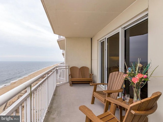 balcony with a water view and a view of the beach