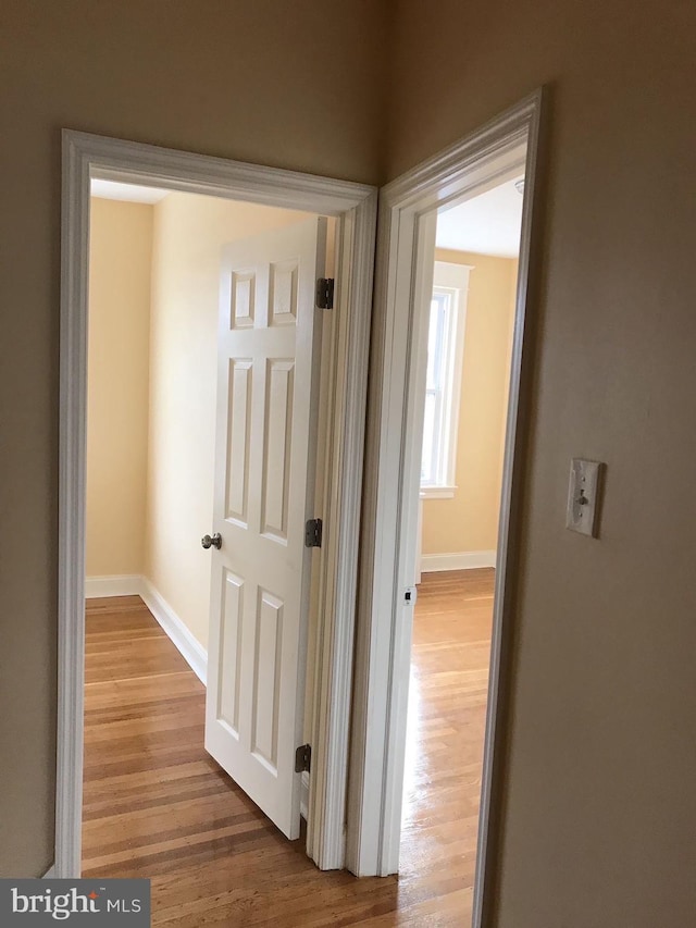 hallway with wood finished floors and baseboards