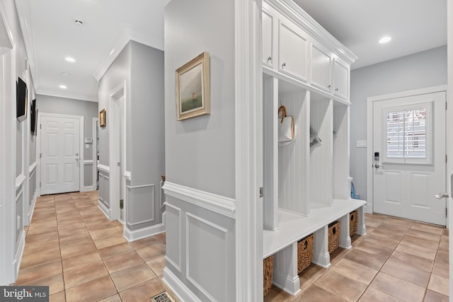 mudroom with recessed lighting, ornamental molding, a decorative wall, and light tile patterned flooring