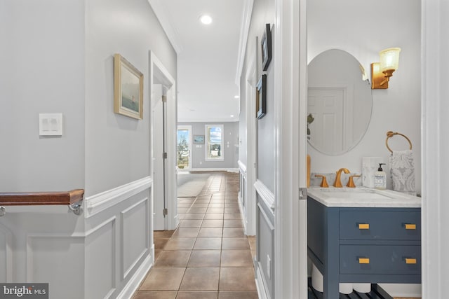 hallway with recessed lighting, tile patterned flooring, a sink, and crown molding