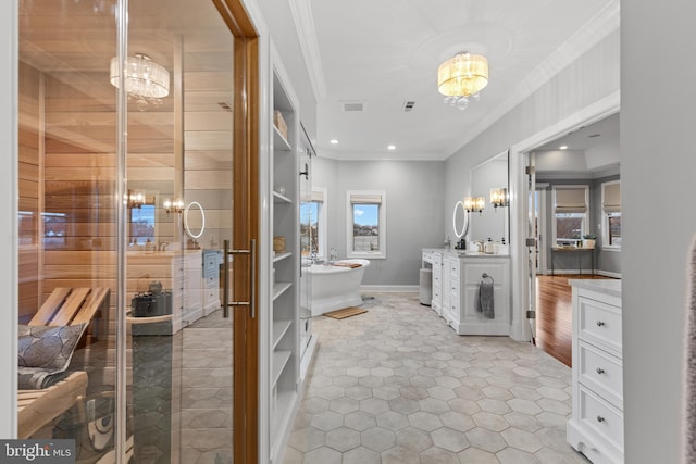 full bathroom featuring crown molding, a freestanding tub, visible vents, and an inviting chandelier