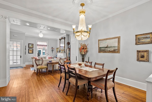 dining room featuring crown molding, baseboards, and wood finished floors