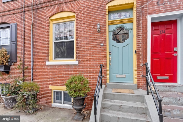 view of exterior entry featuring brick siding