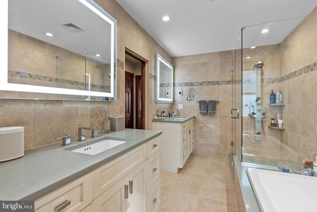 full bath featuring visible vents, a sink, tile walls, and a shower stall