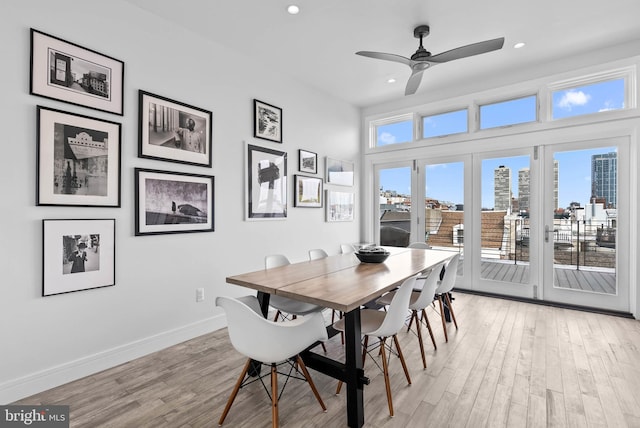 dining area with a view of city, light wood finished floors, baseboards, and recessed lighting