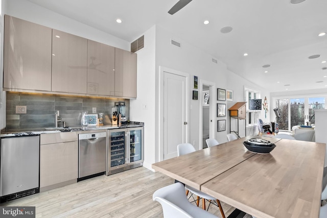 kitchen with wine cooler, gray cabinets, visible vents, stainless steel dishwasher, and a sink