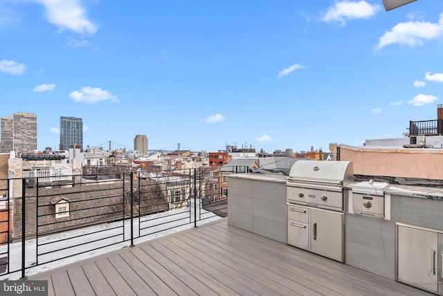 wooden deck featuring a view of city, a grill, and area for grilling