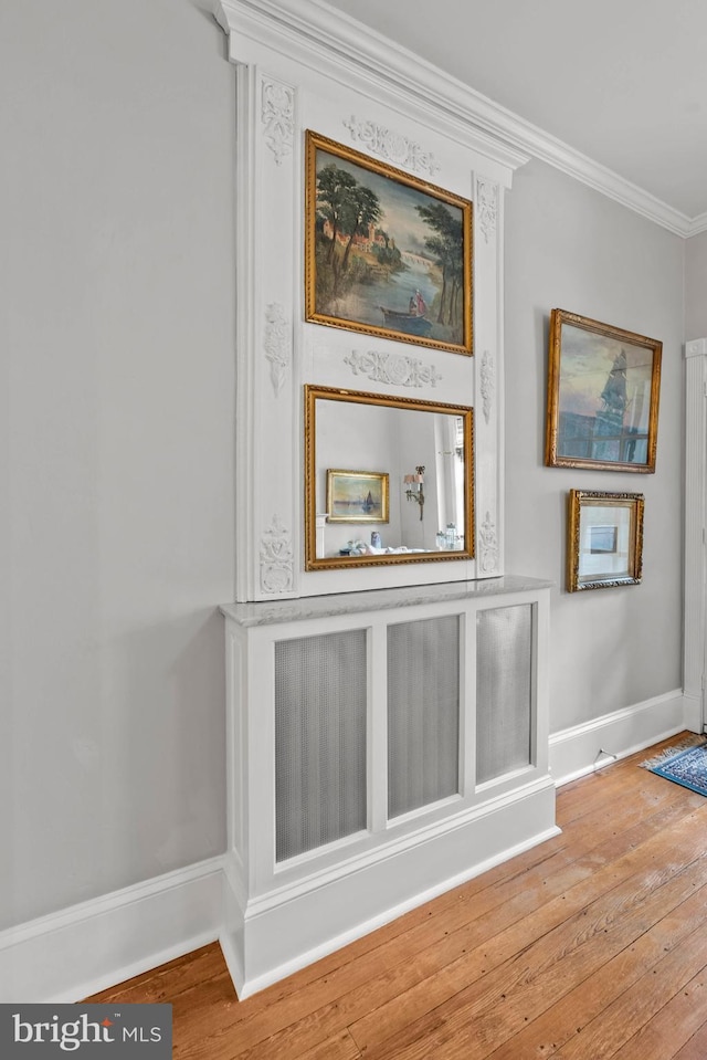 interior details with crown molding, baseboards, and wood finished floors