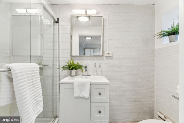 full bath with vanity, tile walls, and a shower stall